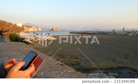 Relaxing with my cell phone in hand on the Naples seafront. 131349199