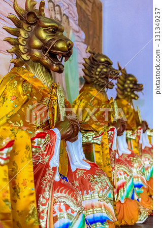 Golden dragon-headed statues in colorful ceremonial robes. Nianshan Park, Sanya, China. March 1, 2024. Golden dragon-headed statues in colorful ceremonial robes. Nianshan Park, Sanya, China. March 1, 2024. 131349257