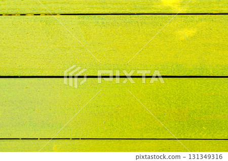 A yellow wooden board with a green stripe A yellow wooden board with a green stripe 131349316