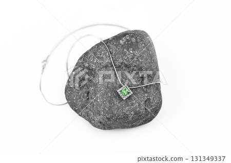 A green emerald necklace is on top of a rock A green emerald necklace is on top of a rock 131349337
