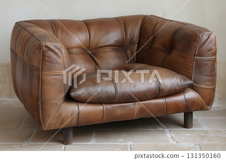 A leather couch with a pillow on it A leather couch with a pillow on it 131350160