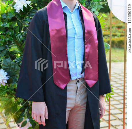 Portraits of student at graduation ceremony with group and family posing outdoors in celebration 131350559
