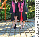 Elegant female student poses proudly in graduation outfit showing beautiful legs and high heels 131350580
