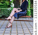 Elegant female student poses proudly in graduation outfit showing beautiful legs and high heels 131350584