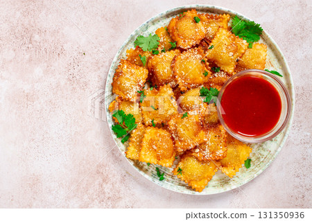 fried ravioli with parmesan cheese, served with red sauce and garnished with herbs, on a light background, no people, fried ravioli with parmesan cheese, served with red sauce and garnished with herbs, on a light background, no people, 131350936