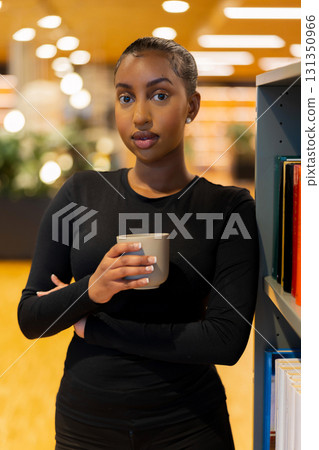 Student holding coffee in a library 131350966