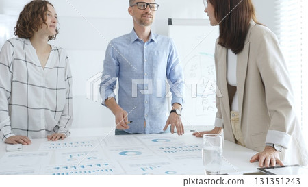 Professional colleagues reviewing financial reports, collaborating on strategic planning in contemporary workspace. Business people concept Professional colleagues reviewing financial reports, collaborating on strategic planning in contemporary workspace. Business people concept 131351243