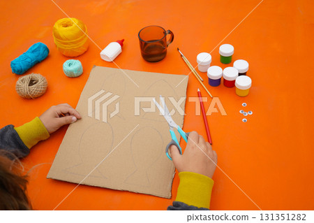 Make a cardboard fish using thread and paint, with detailed instructions, on an orange backdrop. 131351282