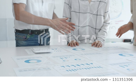 Group of business people is collaborating in modern office environment, analyzing financial data and charts, evaluating performance and developing company growth strategy Group of business people is collaborating in modern office environment, analyzing financial data and charts, evaluating performance and developing company growth strategy 131351306