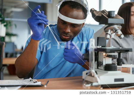 Laboratory with microscope. Group of doctors are together indoors Laboratory with microscope. Group of doctors are together indoors 131351759