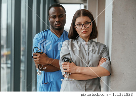 Man and woman doctors are standing together indoors with stethoscope Man and woman doctors are standing together indoors with stethoscope 131351828