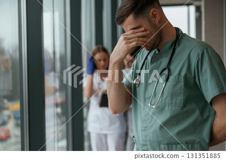 Guy is feeling bad. Group of doctors are together indoors Guy is feeling bad. Group of doctors are together indoors 131351885