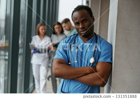African American man is standing in front of colleagues. Group of doctors are together indoors 131351888