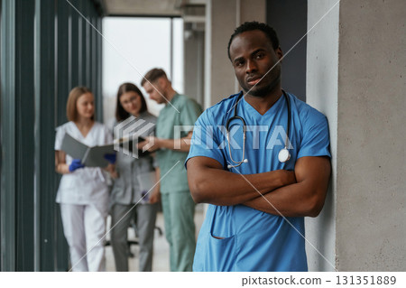 African American man is standing in front of colleagues. Group of doctors are together indoors 131351889