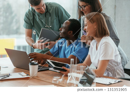 By the table. Group of doctors are together indoors By the table. Group of doctors are together indoors 131351905