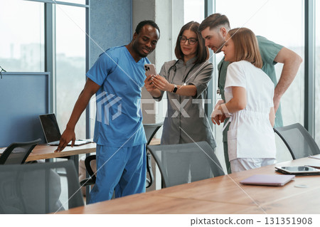 Holding smartphone. Group of doctors are together indoors 131351908