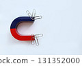 A horseshoe-shaped magnet attracts paper clips. Physical phenomena. View from above 131352000