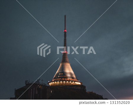 At dusk, the modern Jested Mountain Hotel stands tall, illuminated against a darkening sky. This iconic building in Liberec radiates a unique charm as night approaches. At dusk, the modern Jested Mountain Hotel stands tall, illuminated against a darkening sky. This iconic building in Liberec radiates a unique charm as night approaches. 131352020