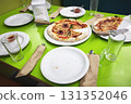 The dining table after dinner with pizza leftovers. A messy kitchen, dirty dishes, leftovers, unsanitary conditions. The kitchen is untidy and careless. Domestic life, everyday life 131352046