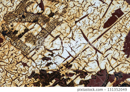 Close-up of cracked peeling paint revealing layers of aged surface with textured detail and burnt tones. Concept of decay, vintage texture and grunge surface background 131352049