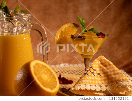 Refreshing orange cocktail with pitcher and fresh fruit 131352131