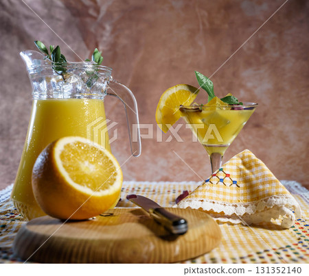 Refreshing orange cocktail with pitcher and fresh fruit 131352140