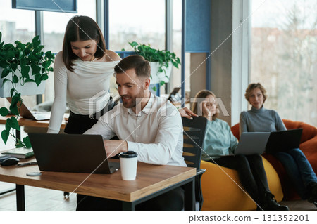 People are working in the office with bean bags chairs in it 131352201