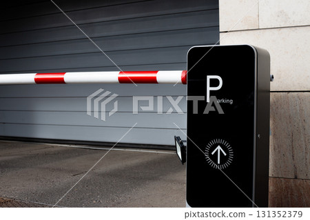 Parking gate with red and white barrier arm and Parking sign. This image highlights modern urban infrastructure and convenience of parking systems Parking gate with red and white barrier arm and Parking sign. This image highlights modern urban infrastructure and convenience of parking systems 131352379