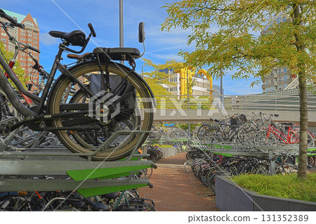 Large multi-level bicycle parking filled with bikes in a busy urban area. Large multi-level bicycle parking filled with bikes in a busy urban area. 131352389