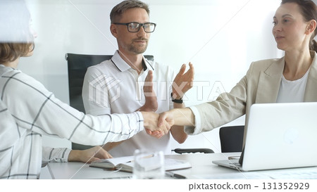 Businesswomen partners are shaking hands after successful negotiation, colleagues clapping, celebrating agreement or partnership in modern office. Handshake concept Businesswomen partners are shaking hands after successful negotiation, colleagues clapping, celebrating agreement or partnership in modern office. Handshake concept 131352929