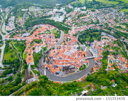 A breathtaking aerial perspective of Cesky Krumlov reveals its charming old town, historic castle, and winding Vltava River, all bathed in the soft light of morning. 131353439