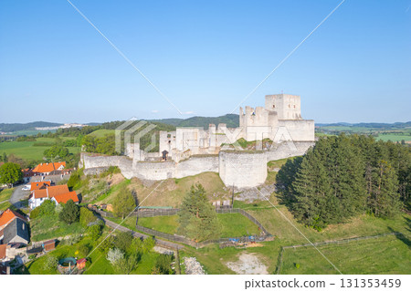 Drone captures an aerial view of the historic Rabi Castle ruins, showcasing its impressive stone structure amidst lush green fields and nearby residential areas in Czechia. Drone captures an aerial view of the historic Rabi Castle ruins, showcasing its impressive stone structure amidst lush green fields and nearby residential areas in Czechia. 131353459