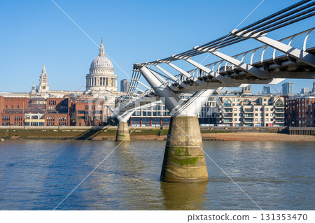Millennium Bridge connects the north and south banks of the Thames. St. Paul's Cathedral rises majestically in the background on a clear day, showcasing London's skyline. Millennium Bridge connects the north and south banks of the Thames. St. Paul's Cathedral rises majestically in the background on a clear day, showcasing London's skyline. 131353470