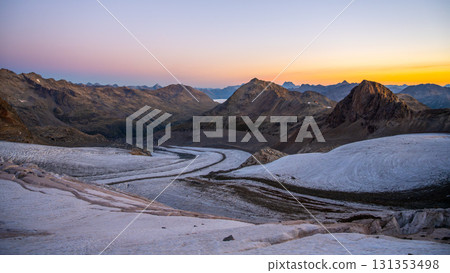 Early morning reveals the stunning beauty of Pers Glacier in the Bernina Range. The sun rises over the majestic peaks, casting soft hues across the rugged alpine landscape. 131353498