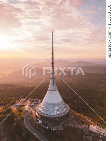 Jested Mountain Hotel stands prominently against a backdrop of evening colors. Located in Liberec, the modern structure features a unique design with a stunning sunset view over the mountains. 131353510