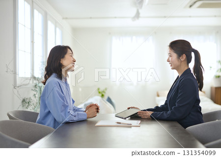 A young businesswoman explaining to a middle-aged woman A young businesswoman explaining to a middle-aged woman 131354099