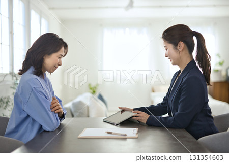 一位年輕女商人向一位中年婦女解釋 131354603