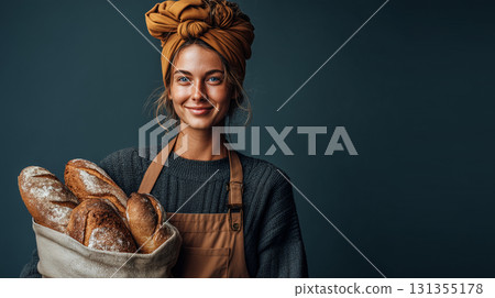一位年輕女工作人員小心翼翼地拿著剛出爐的麵包的照片 | 穿著圍裙和休閒服工作 131355178