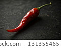 Vibrant red chili pepper rests on a slick, dark background, showcasing fresh cooking ingredient. Glossy texture and dramatic lighting evoke freshness, spice, and bold culinary appeal Vibrant red chili pepper rests on a slick, dark background, showcasing fresh cooking ingredient. Glossy texture and dramatic lighting evoke freshness, spice, and bold culinary appeal 131355465