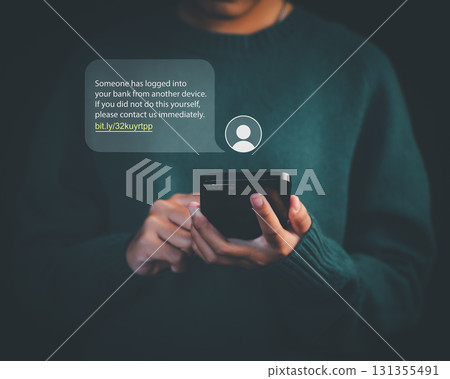 Person holding smartphone with phishing scam message alert about bank login, representing online fraud, cybersecurity threats, identity theft, and internet safety awareness. 131355491