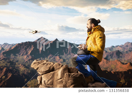 Male influencer shares his hiking journey through a vlog with the drone, recording high quality aerial view content with remote control. Young hiker content creator filming the scenery. 131356838
