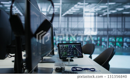 Close up of computer peripherals on server room desk used by employees working to ensure minimal downtime. Hard disk, keyboard and tablet in data center office used for monitoring performance 131356840