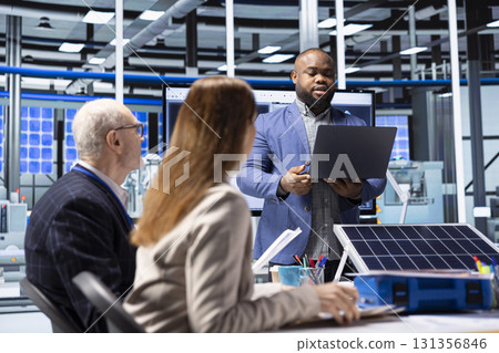African american businessman in solar panels plant looking at data on notebook to evaluate investment strategy. Investor in photovoltaics factory using laptop to review manufacturing expansion options African american businessman in solar panels plant looking at data on notebook to evaluate investment strategy. Investor in photovoltaics factory using laptop to review manufacturing expansion options 131356846