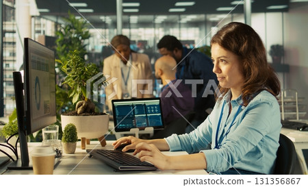Employee at office desk typing on keyboard, editing documents on computer. Worker inputting data on spreadsheets in workplace at PC, working on statistical information, camera B Employee at office desk typing on keyboard, editing documents on computer. Worker inputting data on spreadsheets in workplace at PC, working on statistical information, camera B 131356867