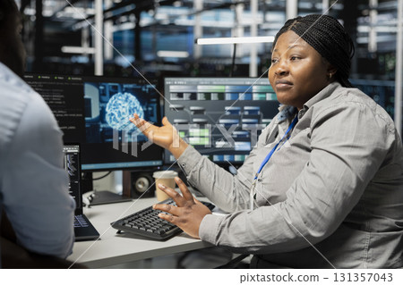 Server room engineering team doing brainstorming, using artificial intelligence to reduce downtime. Teamworking colleagues design and implement AI driven solutions for data center equipment Server room engineering team doing brainstorming, using artificial intelligence to reduce downtime. Teamworking colleagues design and implement AI driven solutions for data center equipment 131357043