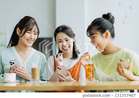 A young woman having a girls-only gathering at a cafe A young woman having a girls-only gathering at a cafe 131357407