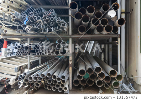 Pipes of various sizes piled up in a messy pile in a materials storage area Pipes of various sizes piled up in a messy pile in a materials storage area 131357472