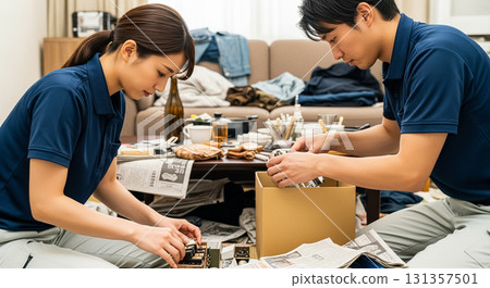 兩名工人，一男一女，正在打掃凌亂的房間。 131357501