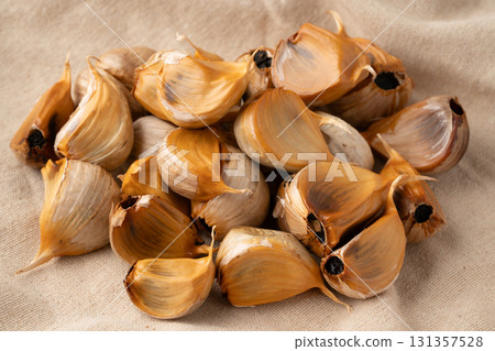 Black garlic (with skin) placed on a cloth 131357528
