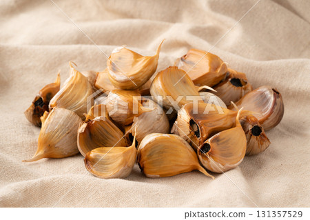 Black garlic (with skin) placed on a cloth 131357529
